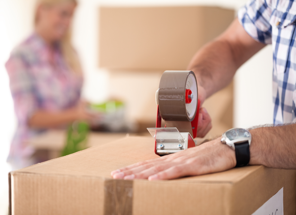 close,up,of,male,hand,packing,cardboard,box,,concept,moving